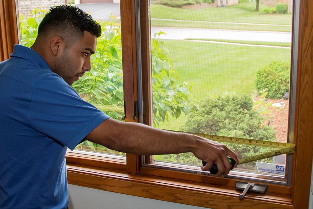 professional installer measuring windows